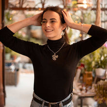 Load image into Gallery viewer, Model wearing RAS Ginkgo Biloba silver pendant necklace over a black top