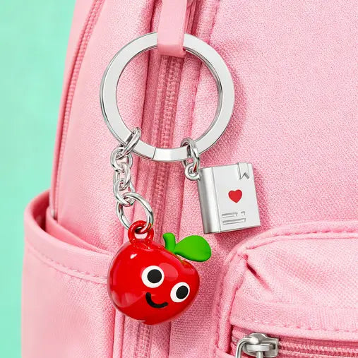 Product on pink bag as charm— keyring angled, charms clearly visible