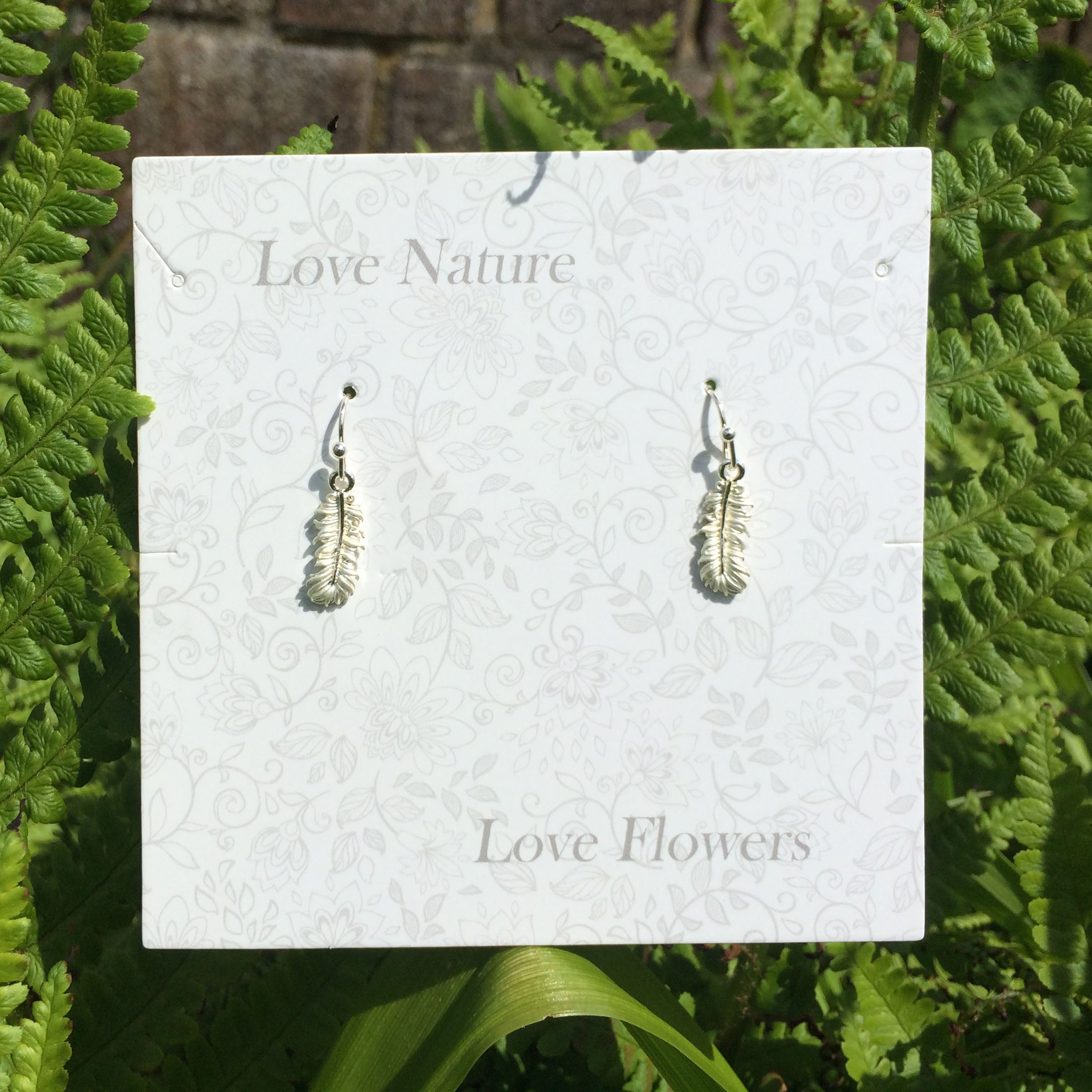 Delicate silver feather earring on presentation card - ORA Gallery