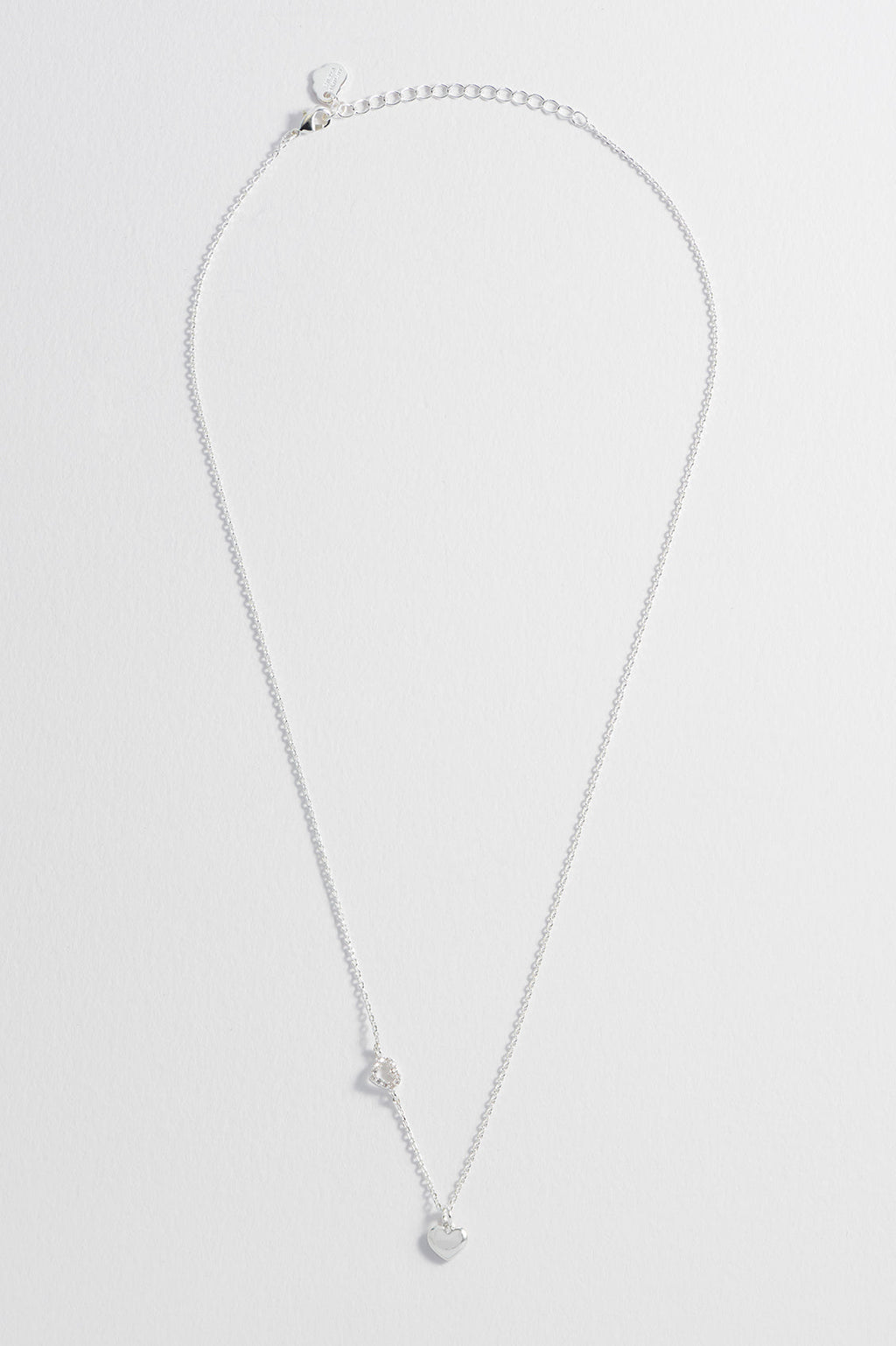 Detail view of the silver CZ heart charm on the Heart Charm With Open CZ Heart Necklace