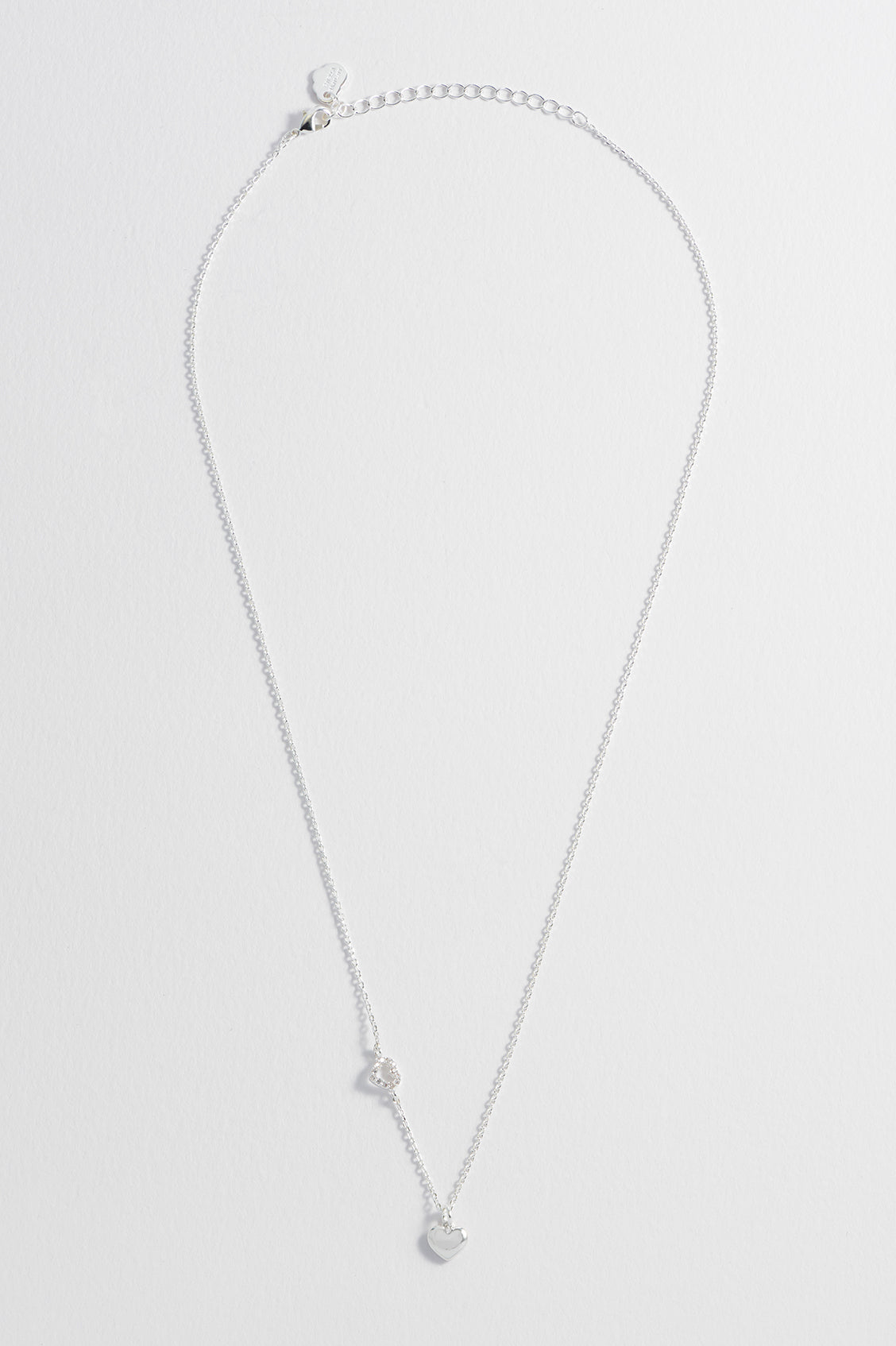 Detail view of the silver CZ heart charm on the Heart Charm With Open CZ Heart Necklace