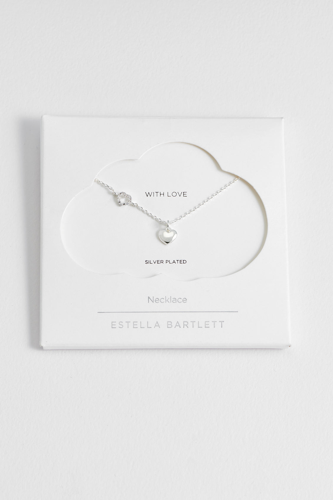 Estella Bartlett Heart Charm With Open CZ Heart Necklace in silver plate, laid flat showing the off-centre heart charm with CZ detailing