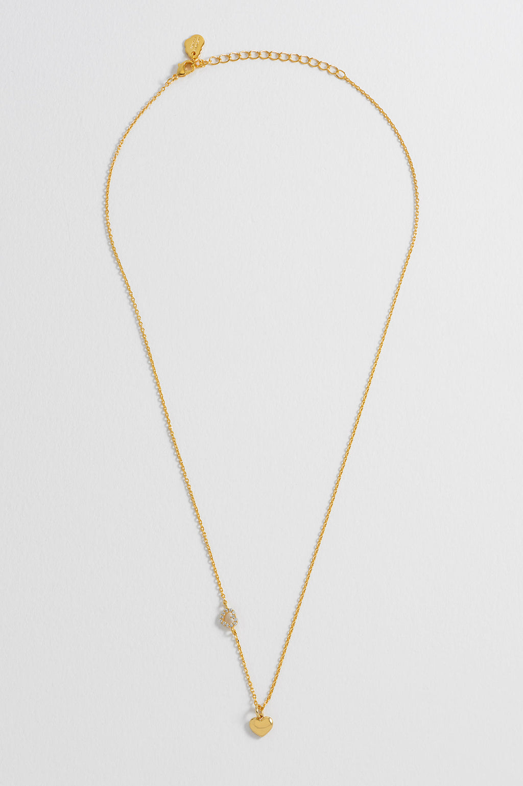 Detail view of the gold CZ heart charm on the Heart Charm With Open CZ Heart Necklace
