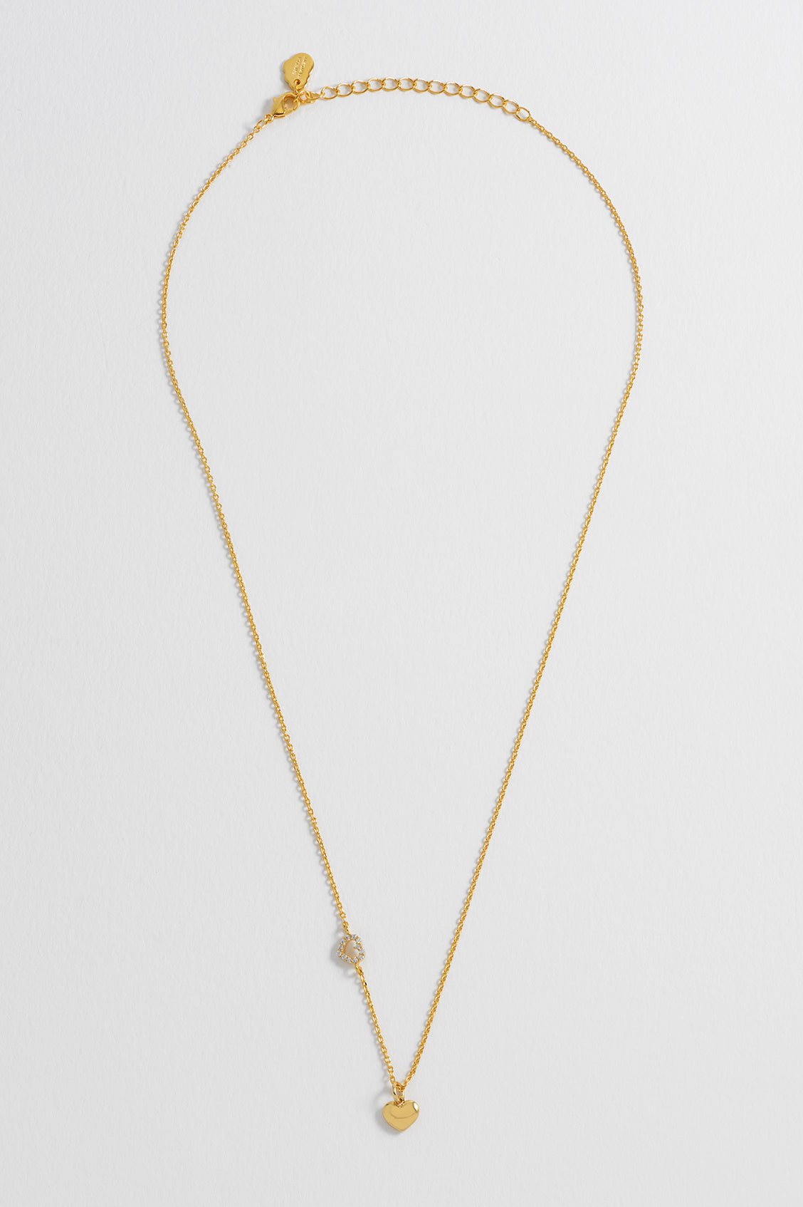 Detail view of the gold CZ heart charm on the Heart Charm With Open CZ Heart Necklace